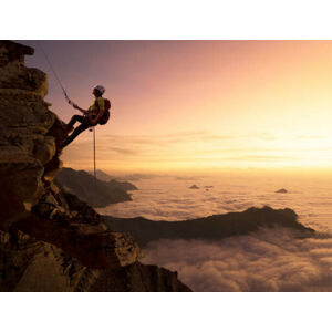 Umělecká fotografie Climber on a rocky wall over clouds, Buena Vista Images, (40 x 30 cm)