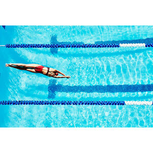Umělecká fotografie Female competitive swimmer diving into pool, Thomas Barwick, (40 x 26.7 cm)