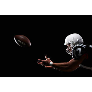 Umělecká fotografie American football player catching ball, side view, Thomas Northcut, (40 x 26.7 cm)