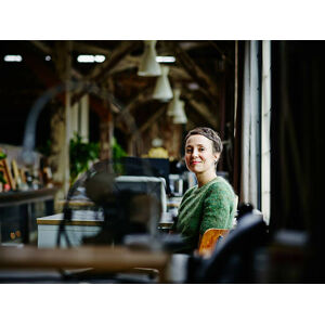 Umělecká fotografie Smiling businesswoman sitting at workstation, Thomas Barwick, (40 x 30 cm)