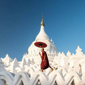 Umělecká fotografie Buddhist monk walking across arches of temple, Martin Puddy, (40 x 40 cm)