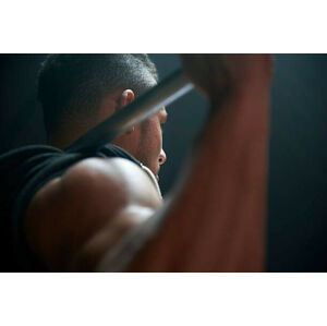Umělecká fotografie Male athlete lifting weight bar black background, Tara Moore, (40 x 26.7 cm)
